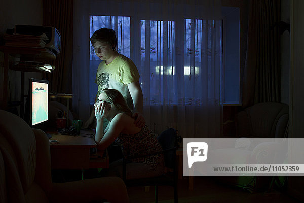 Kaukasisches Paar  das nachts einen Computer benutzt