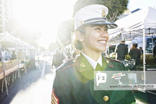 Asiatischer Soldat lächelt auf dem Bauernmarkt