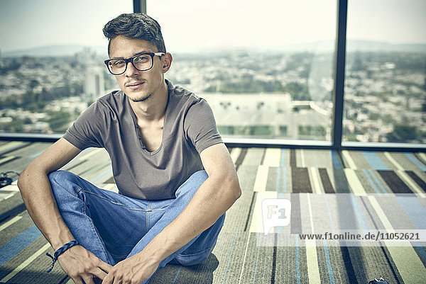Hispanic man sitting on floor