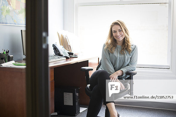 Kaukasische Geschäftsfrau lächelnd im Büro