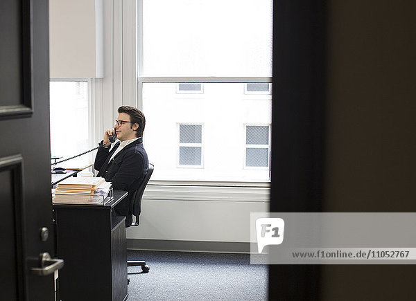 Kaukasischer Geschäftsmann telefoniert im Büro