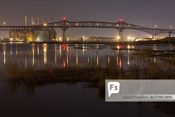 Reflection of illuminated bridge in still lake