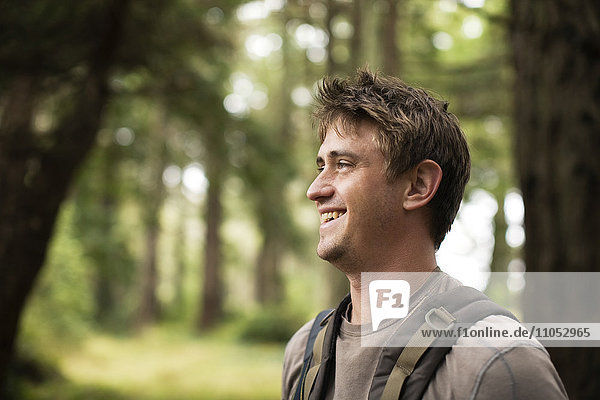 Kaukasischer Mann lächelnd im Wald
