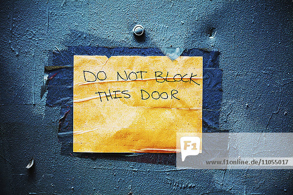 Schild an einer blauen Tür nicht blockieren