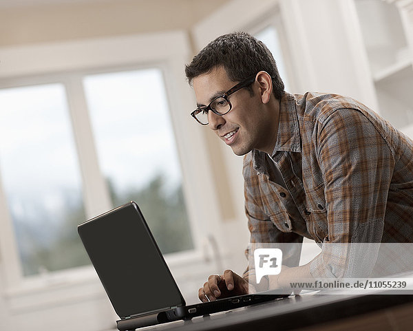 Ein Mann sitzt mit einem Laptop-Computer.