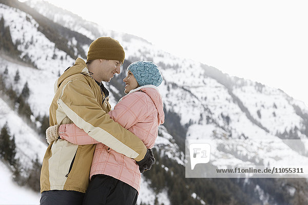 A couple  a man and woman in the snowy mountains.