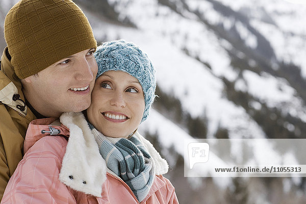 Ein Paar  das sich umarmt  Mann und Frau  in den verschneiten Bergen.
