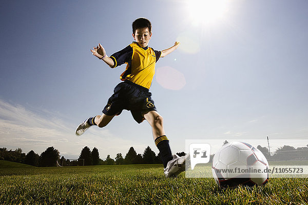 A soccer player  a boy preparing to kick a soccer ball.