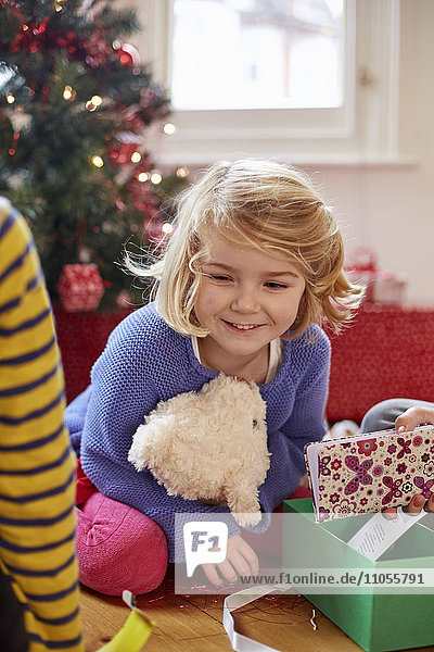 Zwei Kinder am Weihnachtstag finden und packen zu Hause Geschenke aus.