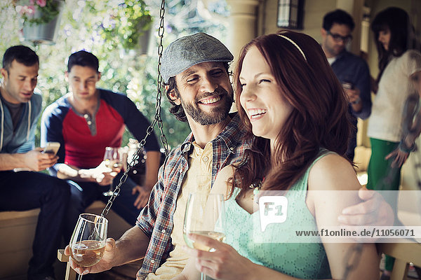 Eine Gruppe von Freunden  Männer und Frauen bei einer Hausparty  die Wein trinken.