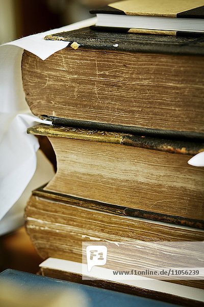 Ein Bücherstapel  mit vergilbten  abgenutzten Seitenrändern und abgenutzten Einbänden.