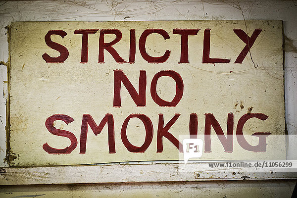 Ein Schild mit der Aufschrift Strictly No Smoking No Smoking an der Wand der Werkstatt eines Möbelherstellers.