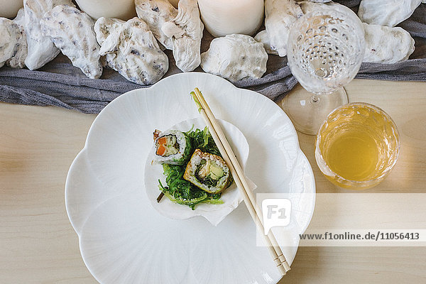 Draufsicht auf Sushi-Teller und einen gedeckten Tisch für ein Festmahl.