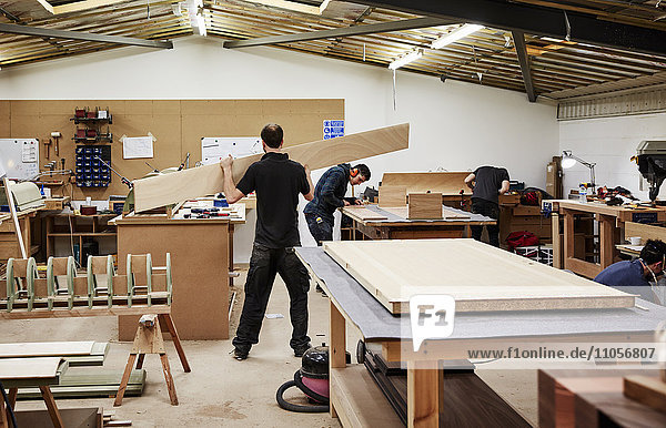 Eine Möbelwerkstatt  die maßgeschneiderte zeitgenössische Möbelstücke unter Verwendung traditioneller Fertigkeiten herstellt. Zwei Männer arbeiten mit Holz