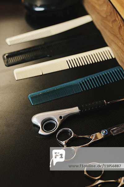 A row of hair combs and sharp hair cutting scissors.