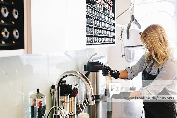 Eine Frau  die mit Handschuhen arbeitet und in einem Friseursalon die Geräte reinigt.