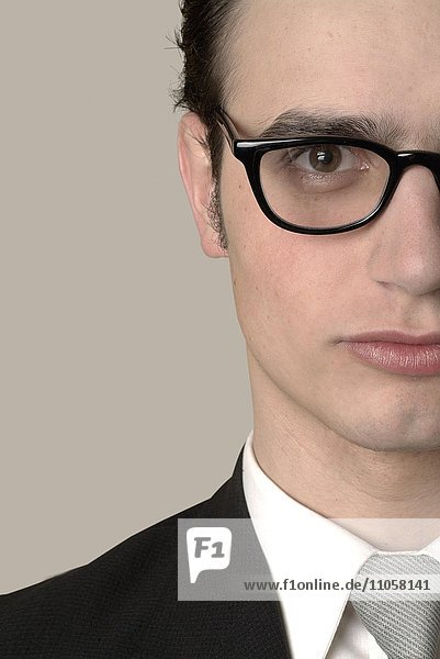 Serious young businessman wearing glasses  cropped portrait