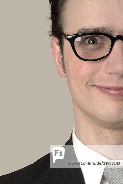Smiling young businessman wearing glasses  cropped portrait