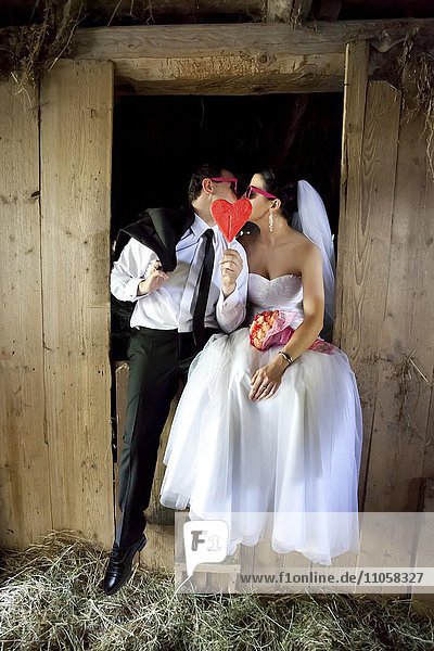Brautpaar küsst sich im Heustadel