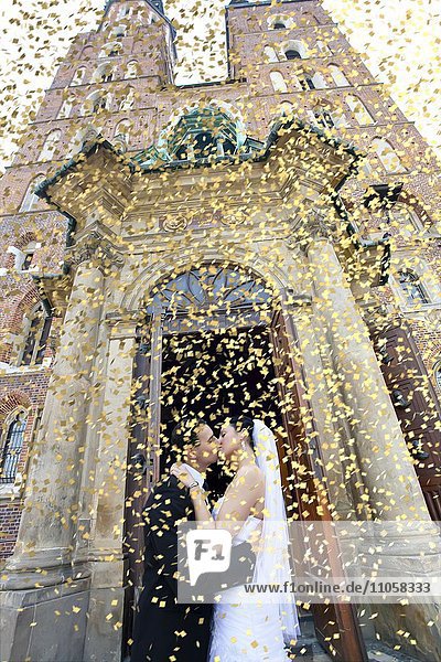 Brautpaar küsst sich vor der Marienkirche  Konfetti  Krakau  Polen  Europa