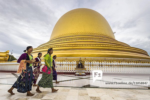 Girls walk in front of Kaunghmudaw pagoda or Yaza Mani Sula Kaunghmudaw or Rajamanicula Sagaing Region Myanmar Burma Asia