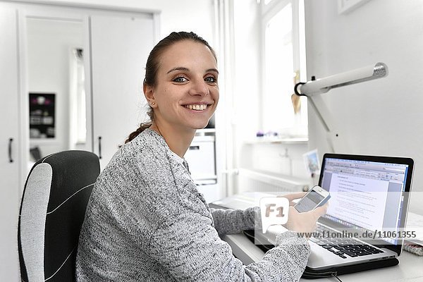 Studentin mit Smartphone und Notebook  Baden-Württemberg  Deutschland  Europa