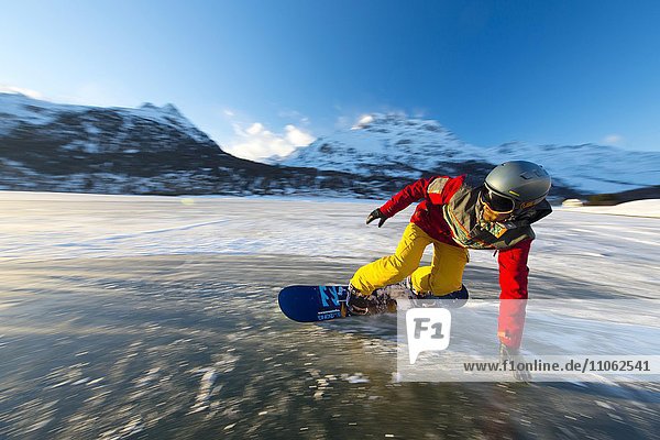 Snowboarder on frozen lake  Lake Silvaplana  Silvaplana  Canton of Grisons  Switzerland  Europe