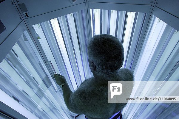 Mann steht in einer Bestrahlungskabine  UV-Lichttherapie bei einem Hautarzt  Dermatologe  Deutschland  Europa