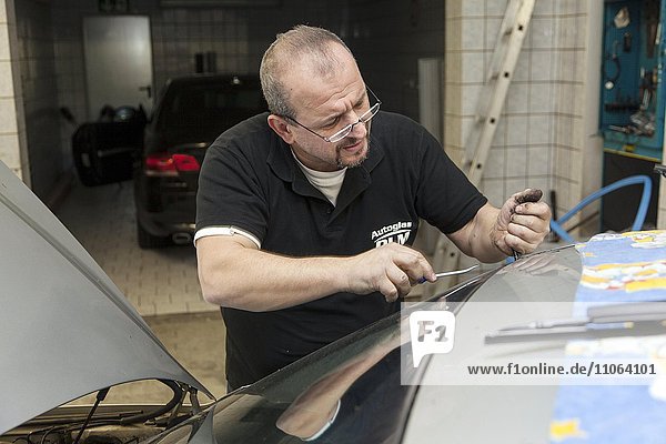 Wechseln der Frontscheibe an einem PKW in einer Kfz-Werkstatt für Autoglas  Düsseldorf  Nordrhein-Westfalen  Deutschland  Europa