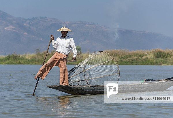 Leg-rowing Intha fisherman with boat on Inle Lake  Burma  Myanmar  Asia