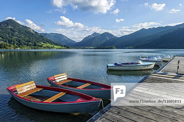 Rowing boats and electric boats at jetty  Schliersee  Markt Schliersee  mountains Brecherspitz and Spitzingsattel  Mangfall mountains  Bavarian Prealps  Upper Bavaria  Bavaria  Germany  Europe