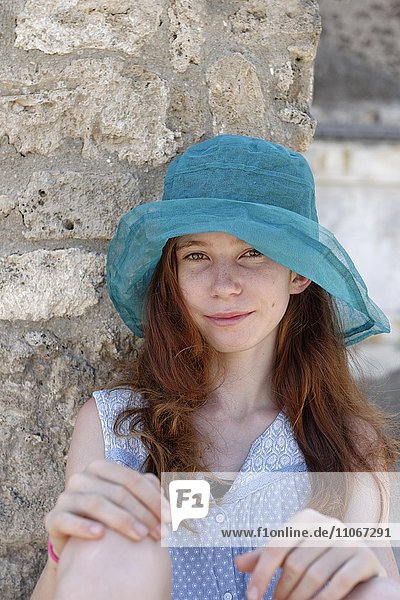 Red-haired girl with a turquoise sun hat smiling  portrait  Italy  Europe