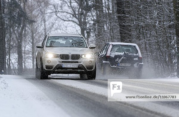 Verschneite Straße mit Autos  Verkehr bei winterlichen Straßenverhältnissen  Gelting  Oberbayern  Deutschland  Europa