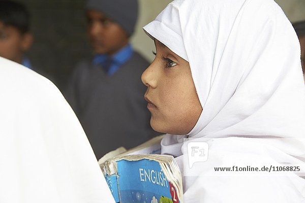 Mädchen mit Englischbuch in der Grundschule  Mahey  Pakistan  Asien