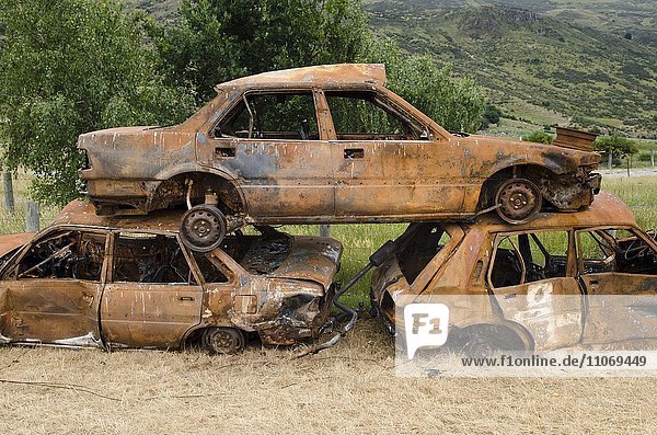 Stapel von drei rostigen Autowracks  Schrottautos  Autofriedhof  Südinsel  Neuseeland  Ozeanien