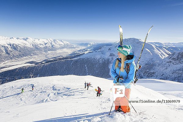 Junge Frau mit Skiern genießt den Ausblick  Axamer Lizum  Innsbruck  Tirol  Österreich  Europa