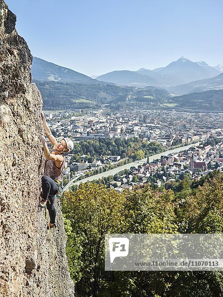 Klettererin mit Helm klettert an einer Felswand  Höttingersteinbruch  Innsbruck  Tirol  Österreich  Europa