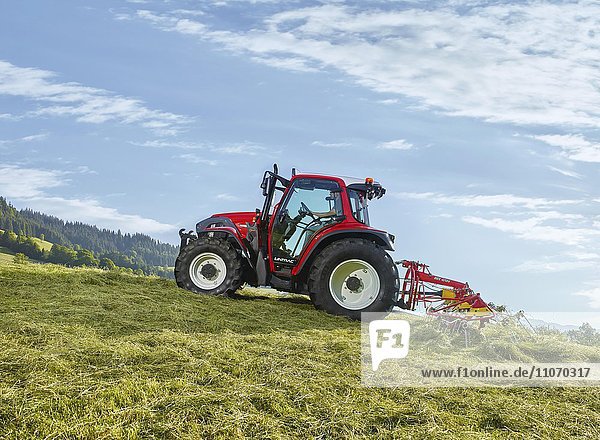 Tractor tedding the freshly cut hay with a tedder  Hopfgarten  Brixental  Tyrol  Austria  Europe
