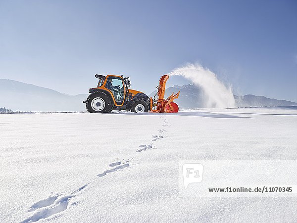 Traktor mit einer Schneefräse bei der Schneeräumung  Winterdienst Einsatz  Kundl  Inntal  Kufstein  Tirol  Österreich  Europa
