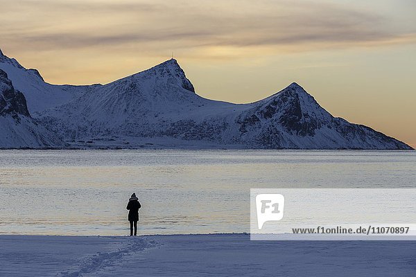 Spaziergänger am schneebedeckten Haukland Strand  Vestvågøy  Lofoten  Nordland  Norwegen  Europa