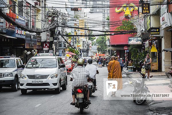 Buddhistischer Mönch läuft auf einer Straße im Straßenverkehr  Ho-Chi-Minh-Stadt  H? Chí Minh  Vietnam  Asien