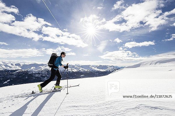 Skitourengeher auf dem Gipfelgrat beim Aufstieg auf die Seeblspitze im Pensertal der Sarntaler Alpen  im Hintergrund die Dolomiten  unten das Sarntal  Südtirol  Trentino-Südtirol  Italien  Europa