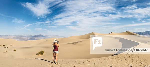 Touristin fotografiert  Mesquite Flat Sand Dunes  Sanddünen  hinten Ausläufer der Amargosa-Range Bergkette  Death Valley  Death-Valley-Nationalpark  Kalifornien  USA  Nordamerika