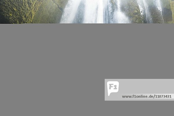Wanderer auf Felsen vor Wasserfall Gljufrabui bei Hamragardar Südisland Island Europa