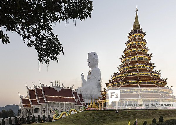 Beleuchteter Wat Huay Pla Kang Tempel in der Dämmerung mit rieseiger Guan Yin Statue  Kuan Yin  Chiang Rai  Nordthailand  Thailand  Asien