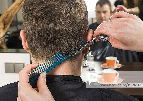 Einem Mann werden die Haare geschnitten  Frisörsalon  Deutschland  Europa