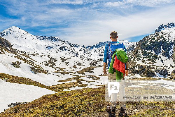 Junger Mann  Wanderer schaut in die Ferne  Berglandschaft mit Schneeresten  Rohrmoos-Untertal  Schladminger Tauern  Schladming  Steiermark  Österreich  Europa