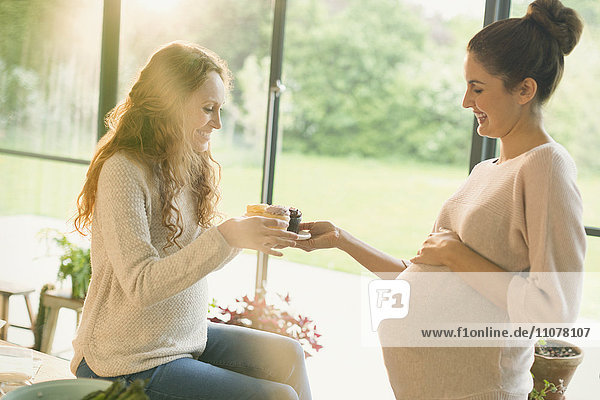 Pregnant women eating cupcakes
