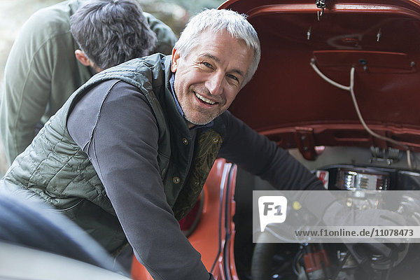 Portrait lächelnder Mechaniker in der Kfz-Werkstatt