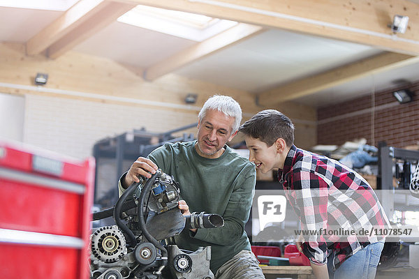 Vater und Sohn beim Motorumbau in der Kfz-Werkstatt